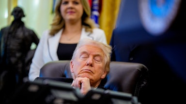 Donald Trump sits at his desk in the Oval Office with his eyes closed