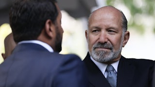 Commerce Secretary Howard Lutnick looks at Kash Patel (who only has the back of his head pictured).