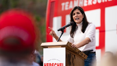 Nikkie Haley speaks at a podium that reads "Herschel for Senate." She is pointing her right finger to emphasize a point.