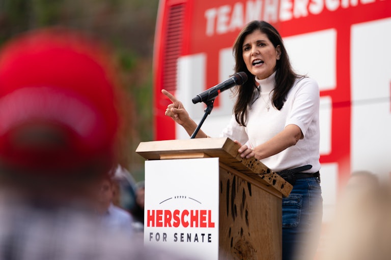 Nikkie Haley speaks at a podium that reads "Herschel for Senate." She is pointing her right finger to emphasize a point.