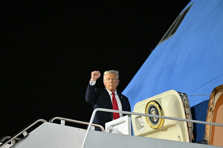 Donald Trump raises his fist while boarding Air Force One