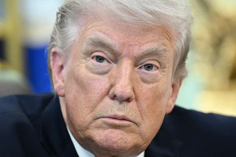 Donald Trump sits at his desk in the Oval Office