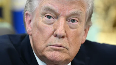 Donald Trump sits at his desk in the Oval Office