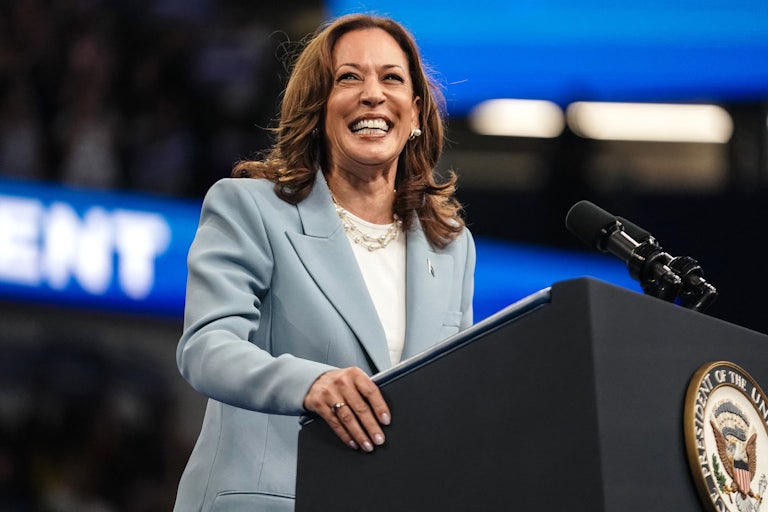 Kamala Harris laughs at a podium