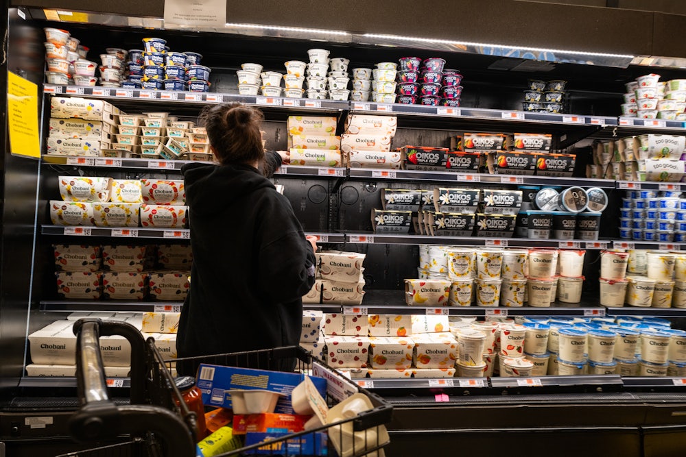 A woman shops in the dairy aisle of a grocery store