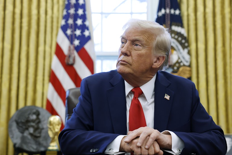 Donald Trump places his hands on his desk in the Oval Office