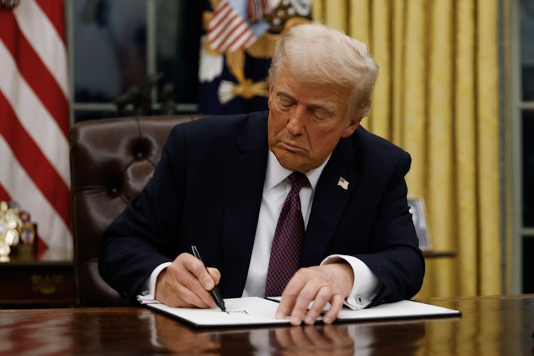 Donald Trump signs an executive order in the Oval Office