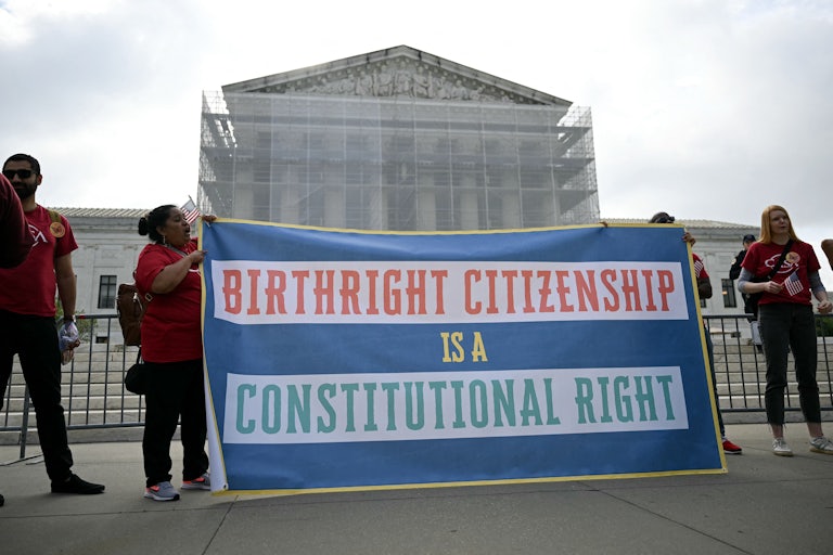 People hold up a banner that says, "Birthright citizenship is a constitutional right" outside the Supreme Court