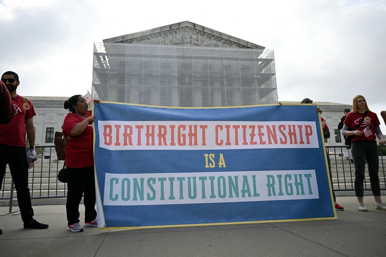 People hold up a banner that says, "Birthright citizenship is a constitutional right" outside the Supreme Court
