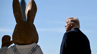 Donald Trump stands next to a waving Easter Bunny during the White House Easter egg roll