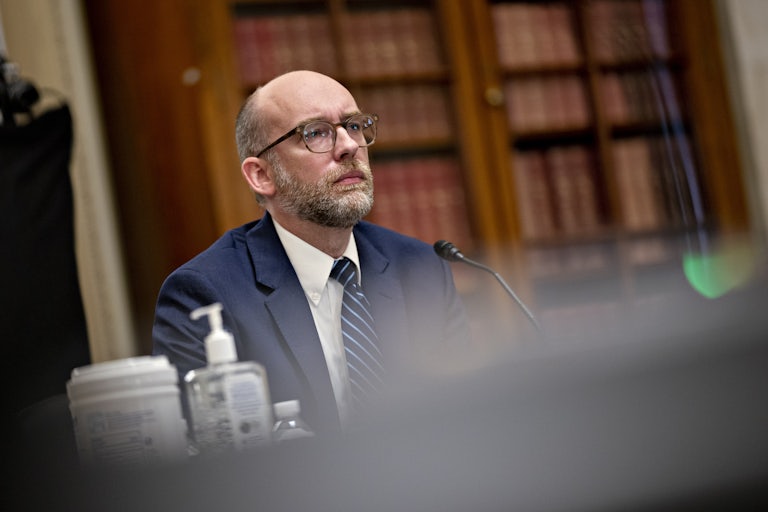 Russell Vought sits in a Senate hearing