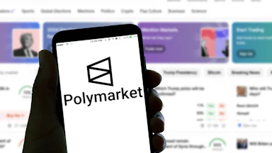 A hand holds a phone with the Polymarket logo. A screen in the background also shows the Polymarket homepage, featuring an image of Donald Trump.