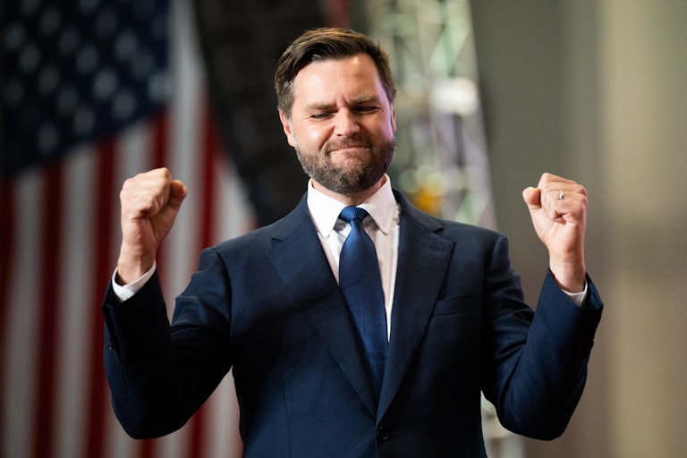 J.D. Vance holds up both his fists during a campaign rally