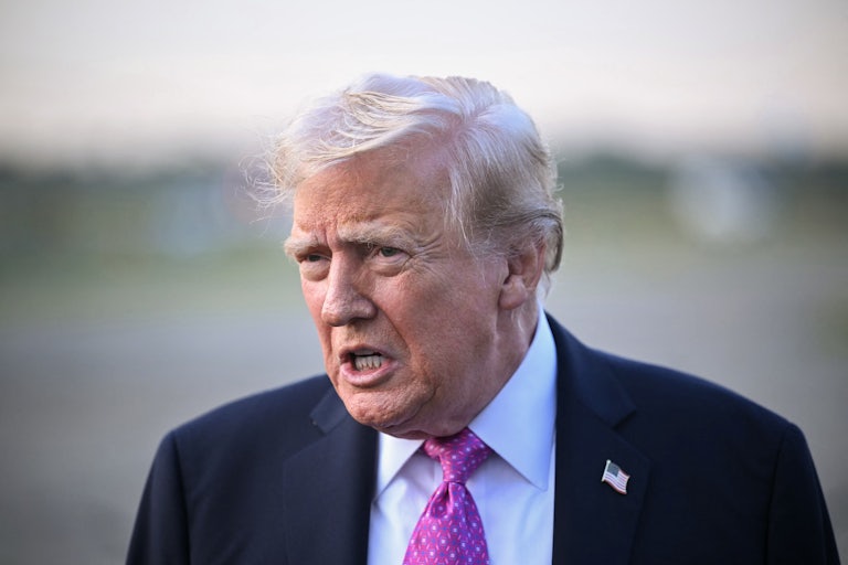 Donald Trump speaks to reporters on a tarmac before boarding Air Force One