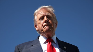 Donald Trump stands with his lips pressed together and his eyes closed