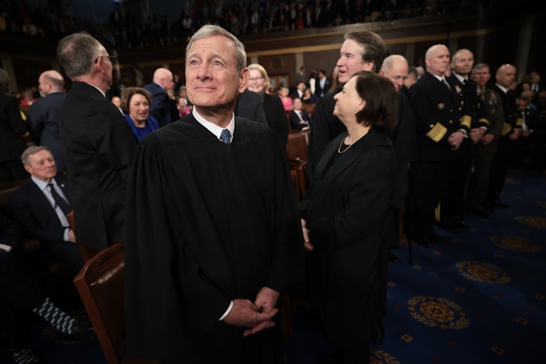 Supreme Court Chief Justice John Roberts smiles and clasps his hands at Trump's joint session to Congress. Behind him are Justices Elena Kagan and Brett Kavanaugh.