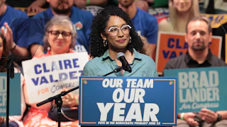 Congressional candidate Darializa Avila Chevalier stands at a podium that reads "Our Team, Our Year." Supporters in the background hold signs with the names of Claire Valdez and Brad Lander.
