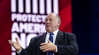 Tom Homan, wearing a suit, speaks while seated in an arm chair.
