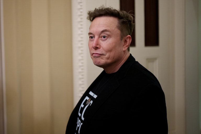 Elon Musk raises his eyebrow and wears a shirt reading "Tech Support"