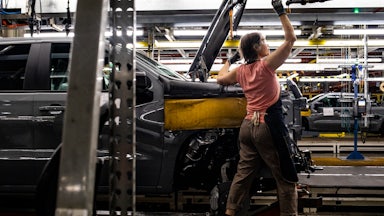 A worker installs an engine at the General Motors assembly plant in Fort Wayne, Indiana.