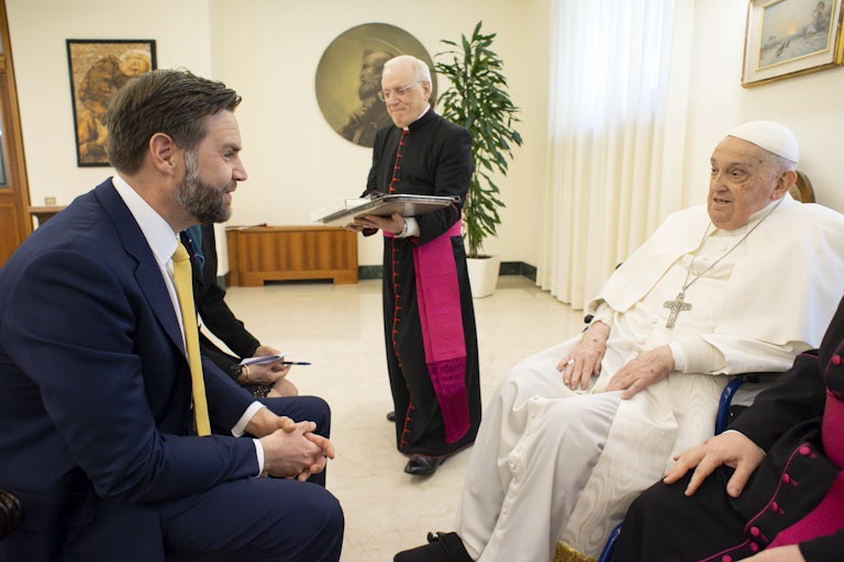 J.D. Vance sits across from Pope Francis and excitedly speaks to him.