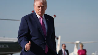 President Donald Trump gives a thumbs up on the tarmac