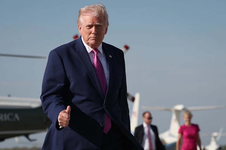 President Donald Trump gives a thumbs up on the tarmac