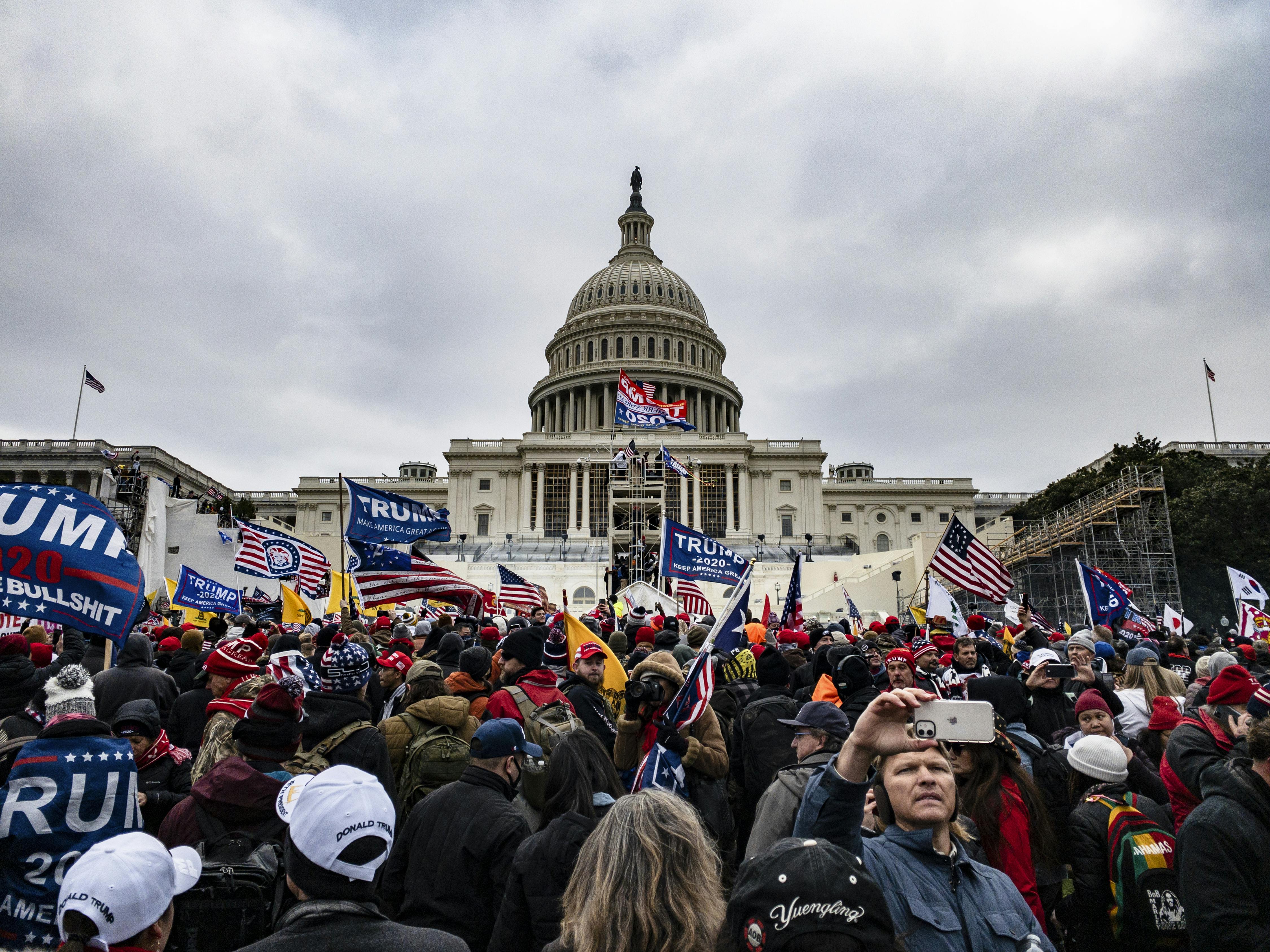 Rioters wave Trump flags as they stand outside the U.S. Capitol in Washington on January 6, 2021