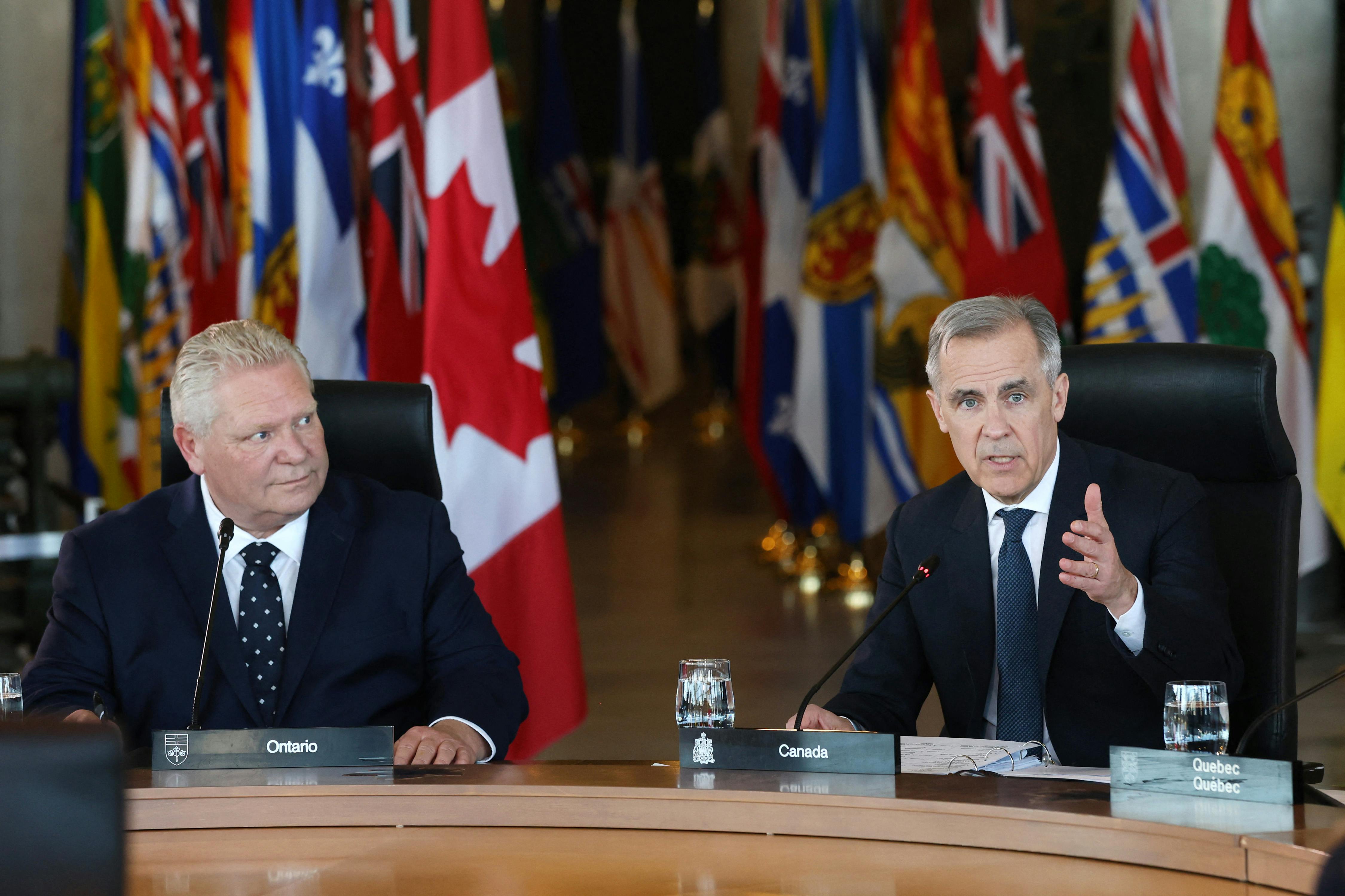 Canada’s Prime Minister Mark Carney speaks as Ontario premier Doug Ford looks on.
