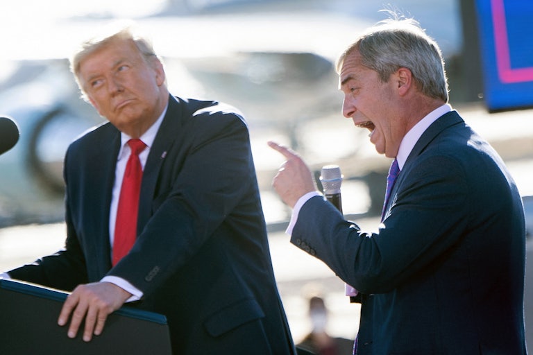 Donald Trump looks quizzically as Nigel Farage points and opens his mouth really big at a rally.