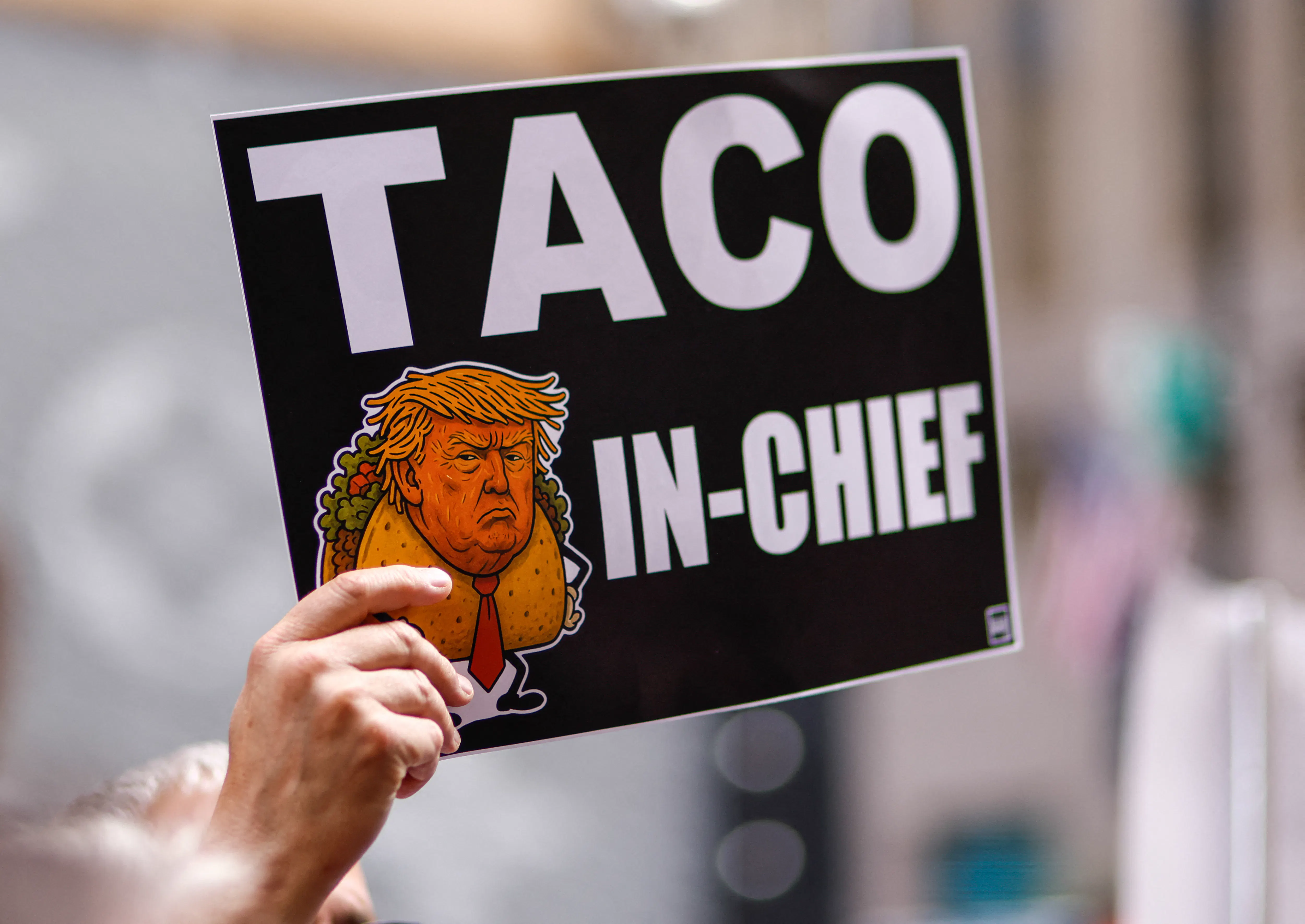 A person holds a sign with an image of Donald Trump as Taco in Chief as people demonstrate during a Labor Day “Workers over billionaires” rally outside Trump Tower in New York City on September 1, 2025. 
