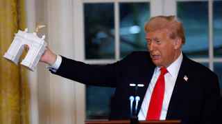 Trump holds a model of his proposed arch