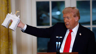Trump holds a model of his proposed arch