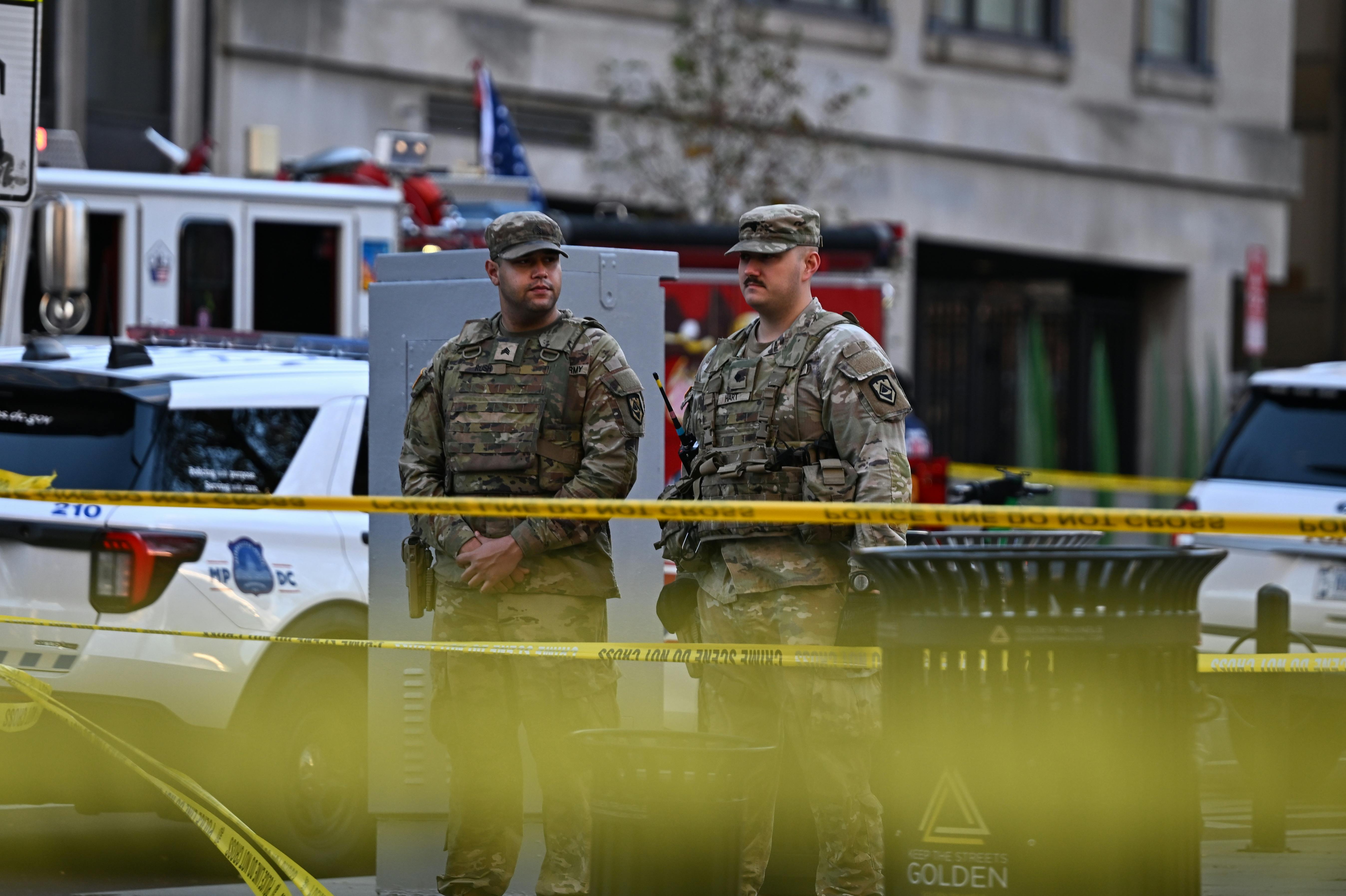 Two members of the National Guard stand in front of caution tape in Washington, D.C.