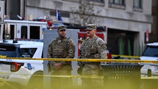 Two members of the National Guard stand in front of caution tape in Washington, D.C.