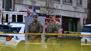 Two members of the National Guard stand in front of caution tape in Washington, D.C.