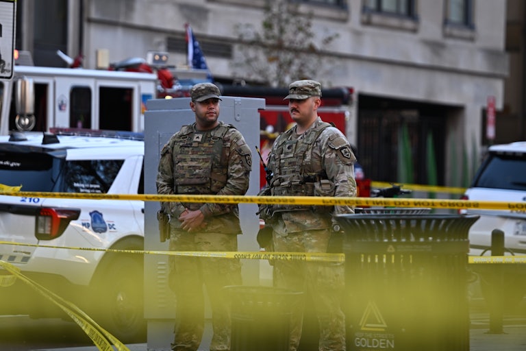Two members of the National Guard stand in front of caution tape in Washington, D.C.