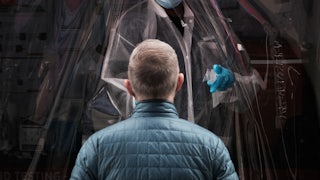 A person stands in front of a medical worker, waiting to be tested.