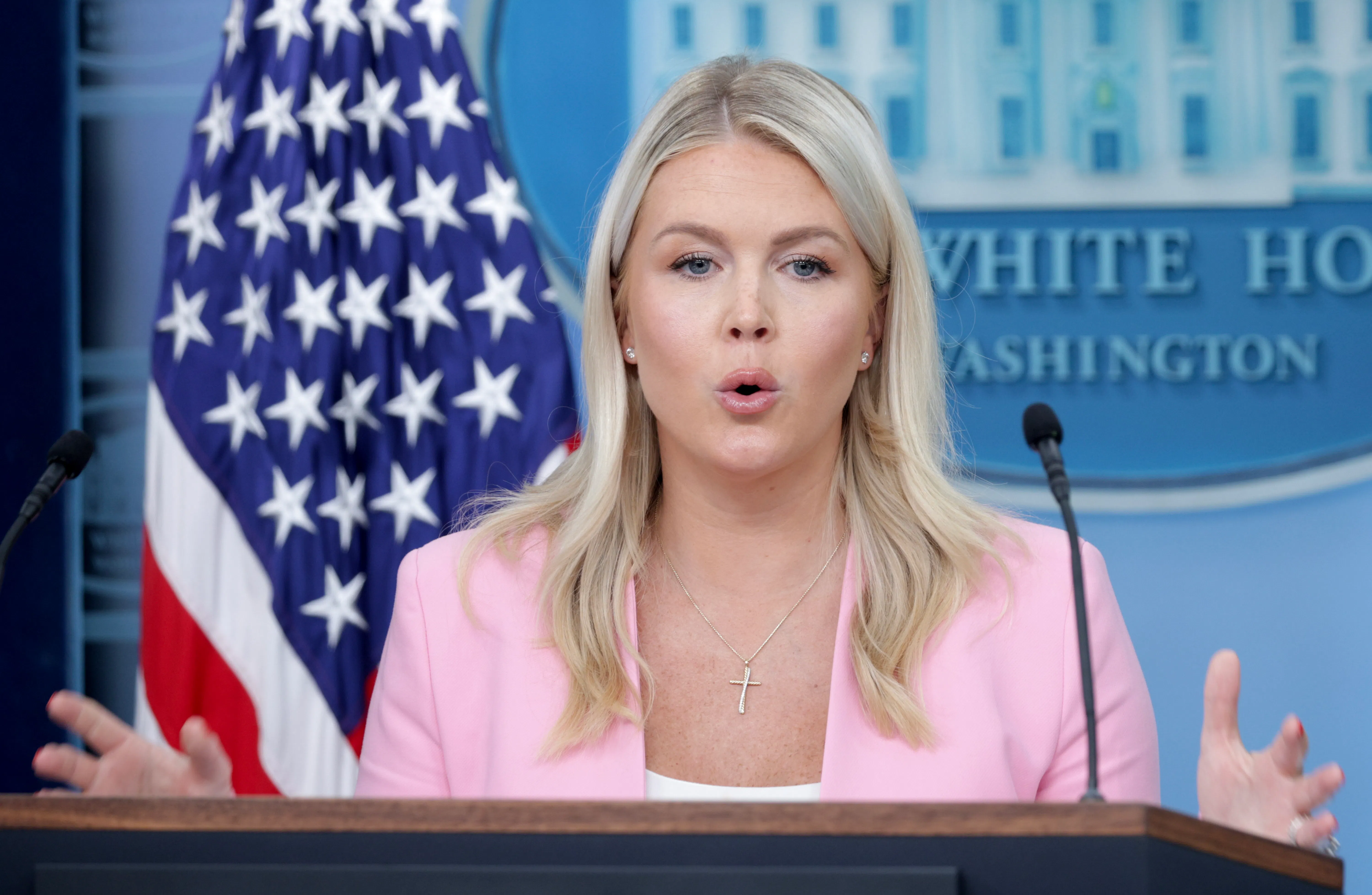 Karoline Leavitt gestures while speaking at the podium in the White House press briefing room