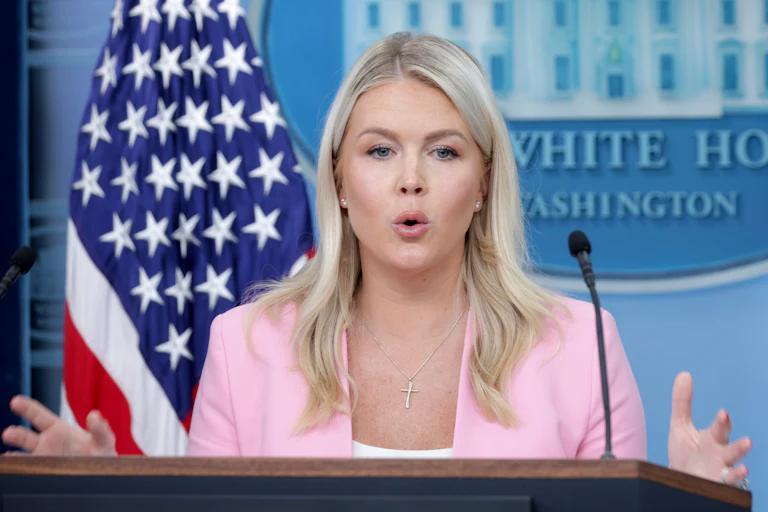 Karoline Leavitt gestures while speaking at the podium in the White House press briefing room