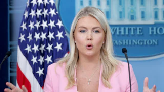Karoline Leavitt gestures while speaking at the podium in the White House press briefing room