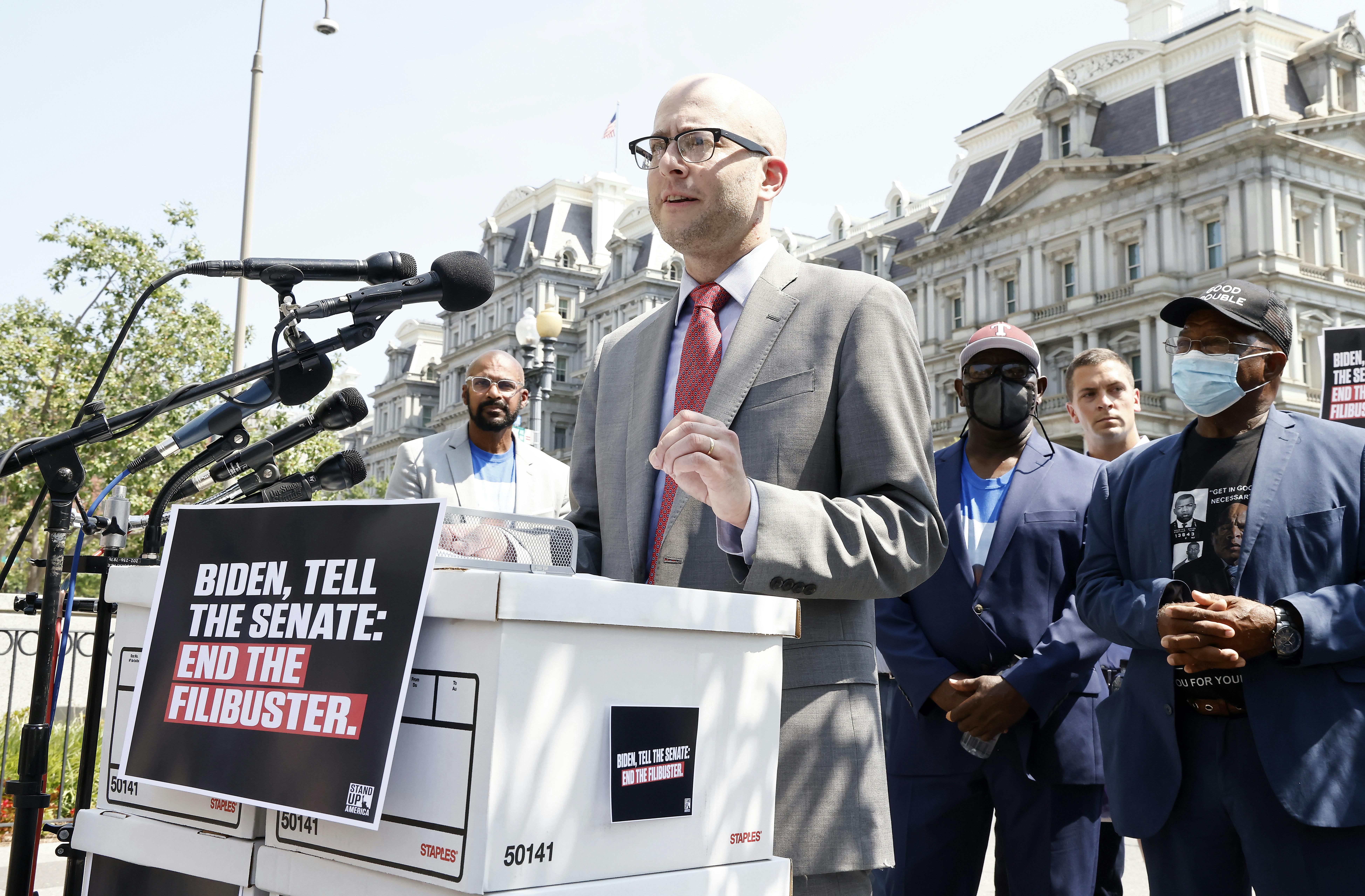 Eli Zupnick stands behind a lectern at a rally against the Senate filibuster.