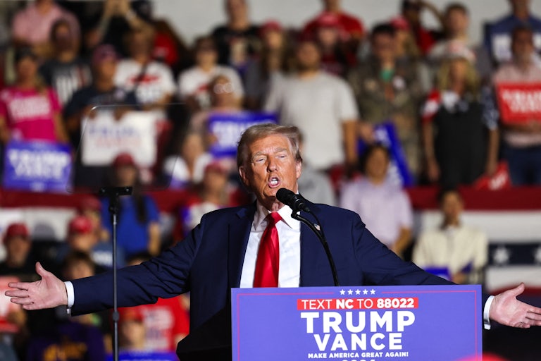 Donald Trump holds his arms out while speaking at a campaign event