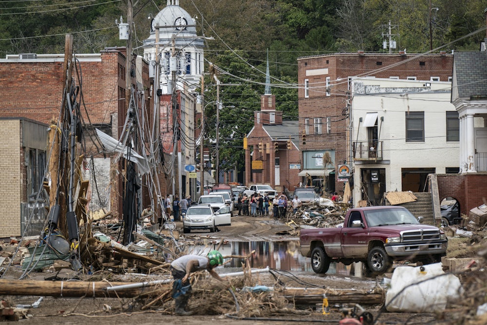 A downtown street is seen covered in wreckage with standing water in the streets.
