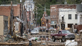 A downtown street is seen covered in wreckage with standing water in the streets.