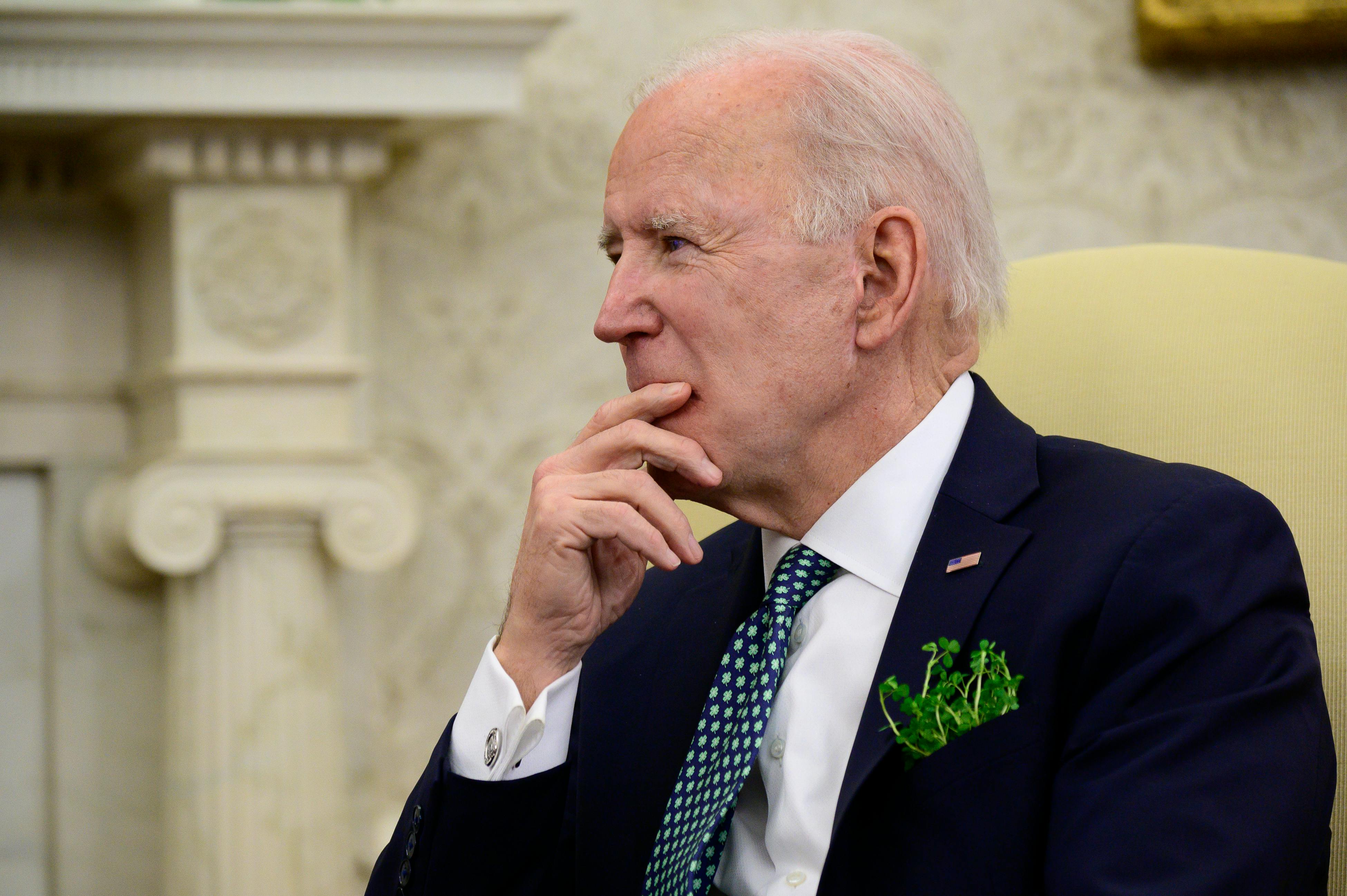 Joe Biden listens during a conference call in the Oval Office.