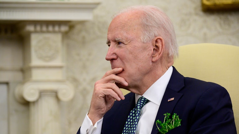 Joe Biden listens during a conference call in the Oval Office.
