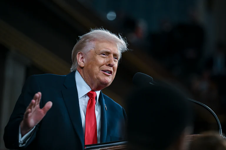 President Trump delivers his State of the Union address at a lectern.