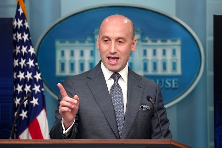 Stephen Miller points a finger while speaking behind the lectern in the White House press briefing room.