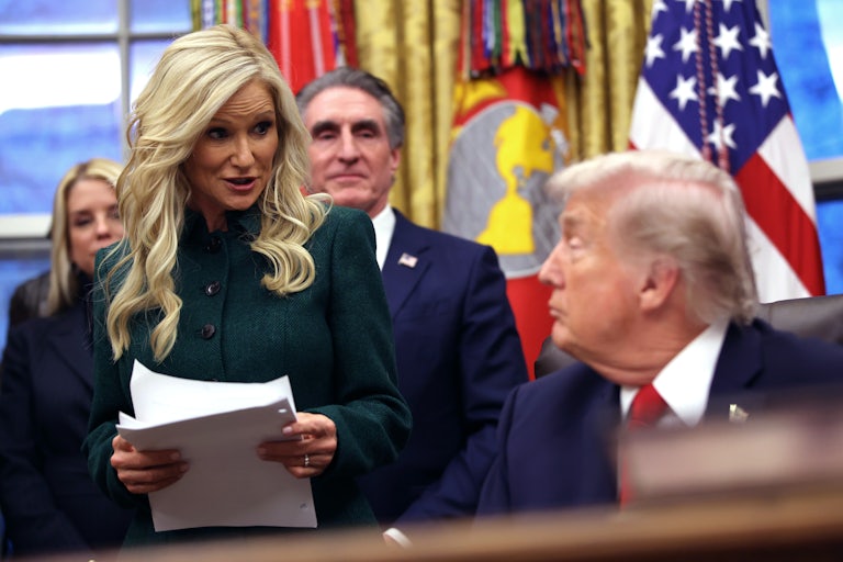Kathryn Burgum stands in front of her husband Doug Burgum and speaks to Donald Trump, who sits at his desk in the Oval Office